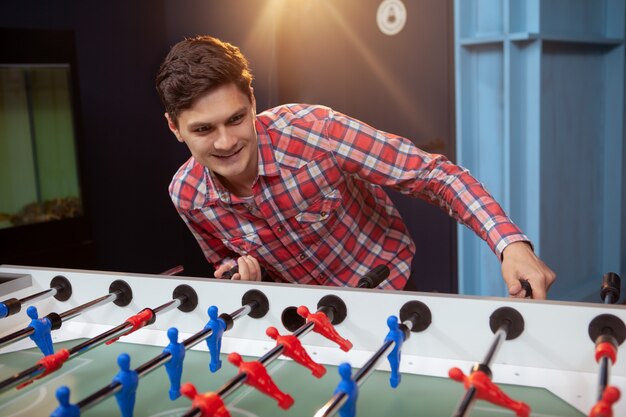 Young man playing table soccer