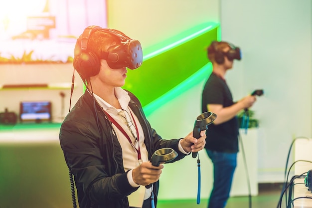 Young man playing video games virtual reality glasses cheerful man having fun with new trends