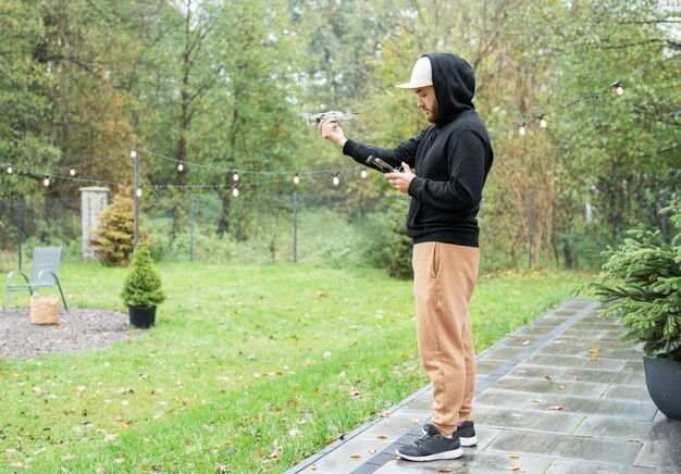 Young man playing with drone outdoors