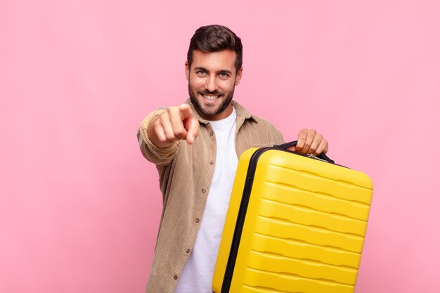 Young man pointing at camera with a satisfied, confident, friendly smile, choosing you. holidays concept