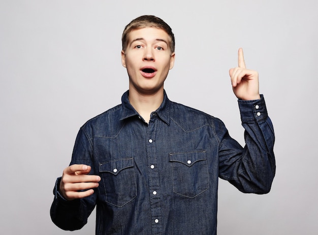 Young man pointing a great idea isolated over a white background