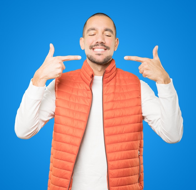 Young man pointing to his teeth