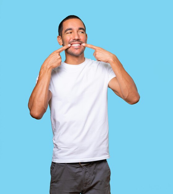 Young man pointing to his teeth