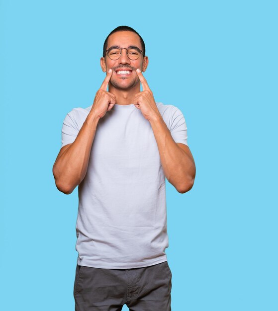 Young man pointing to his teeth