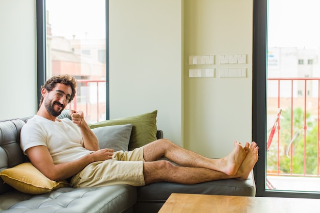 Giovane che indica con un sorriso soddisfatto, fiducioso, amichevole, scegliendo te