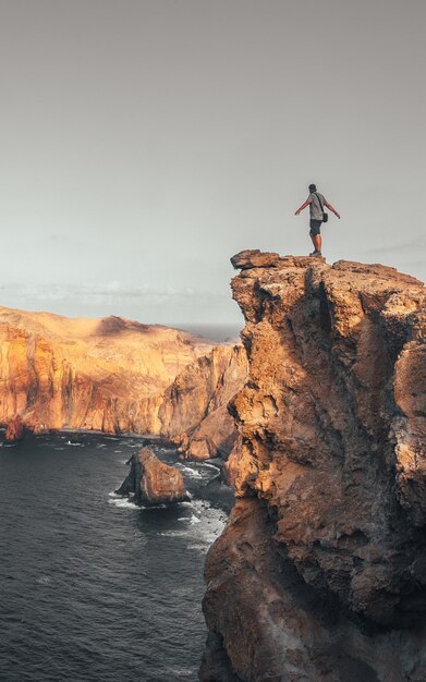 A young man in Ponta de Sao Lourenco on the coast with rock formations Madeira vintage color