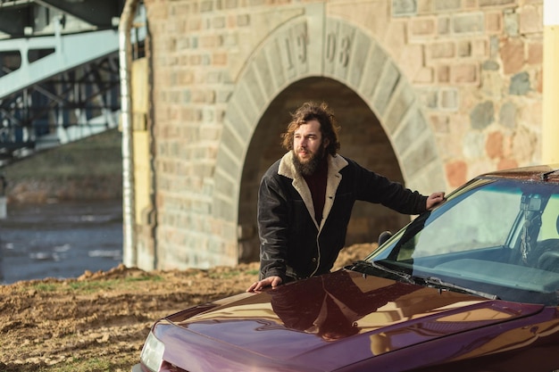 Young man poses with his car