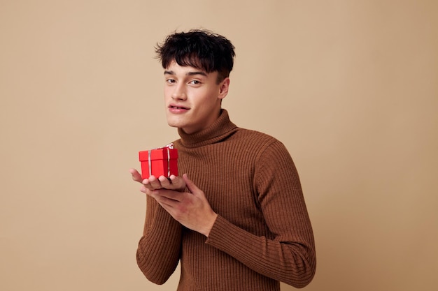 A young man posing in brown sweater self confidence fashion light background unaltered