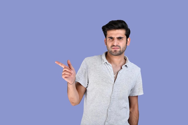 Young man posing infront wearing summer clothes pointing aside indian pakistani model