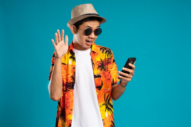 Young man posing in shock while looking at the smartphone he is holding