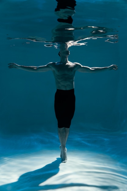 Foto giovane uomo in posa sommerso sott'acqua