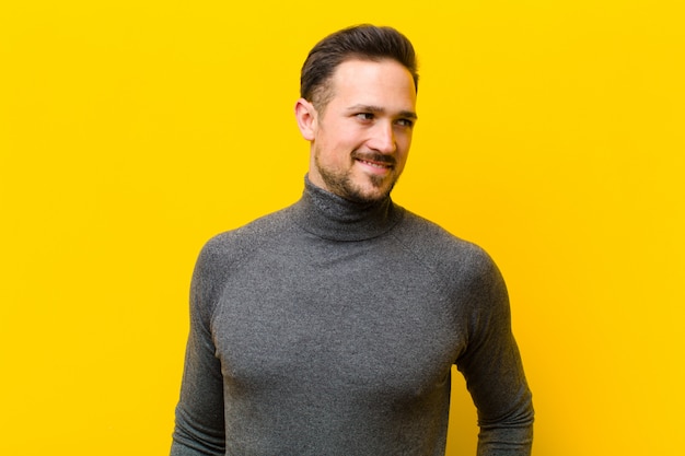 a young man posing while looking to side with both hands on hips