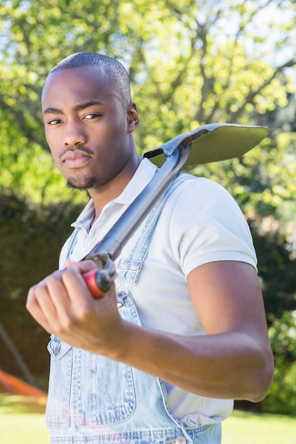 Young man posing with a shovel