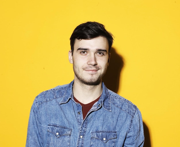 Photo young man posing over yellow background casual style