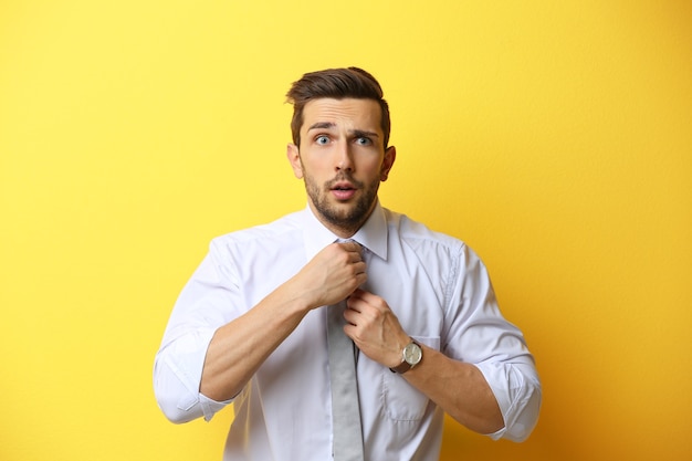 Young man posing on yellow wall
