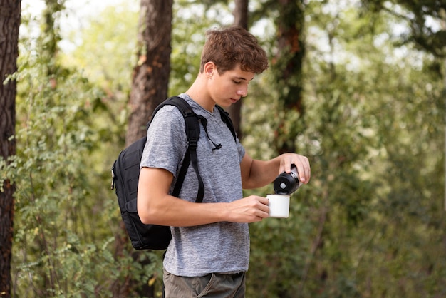 Photo young man pouring drink into cup