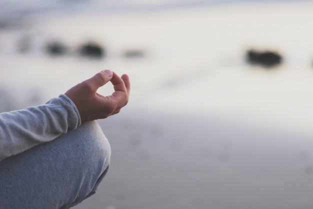 Photo young man practice yoga on the beach at sunset.