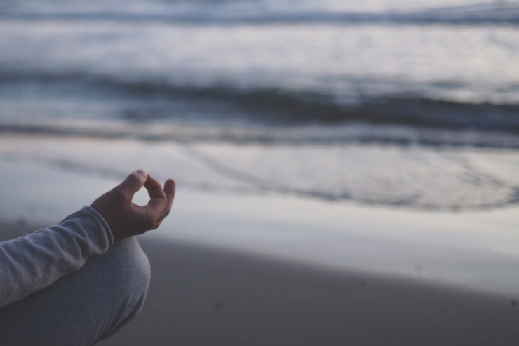Photo young man practice yoga on the beach at sunset.
