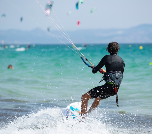 Photo young man practicing kite surfing
