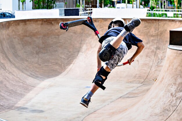 Young man practicing Scootering Freestyle Scootering at the Igualada SkatePark Barcelona Sports