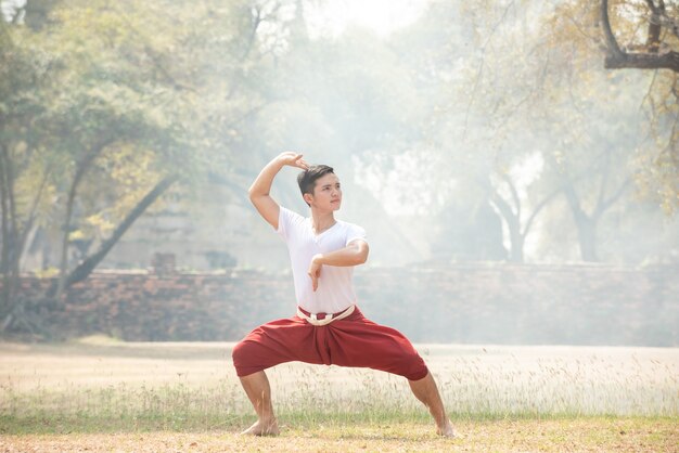 Young man practicing a traditional Thai dance