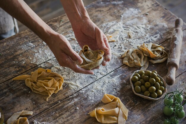 The young man prepares homemade pasta at rustic kitchen