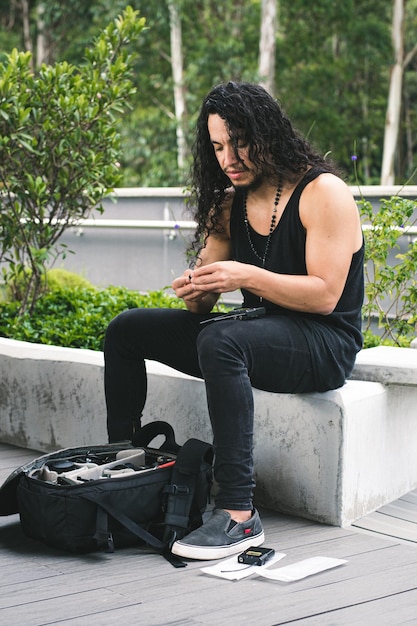 Young man preparing his cameras and microphones to make a video. Long-haired Colombian man