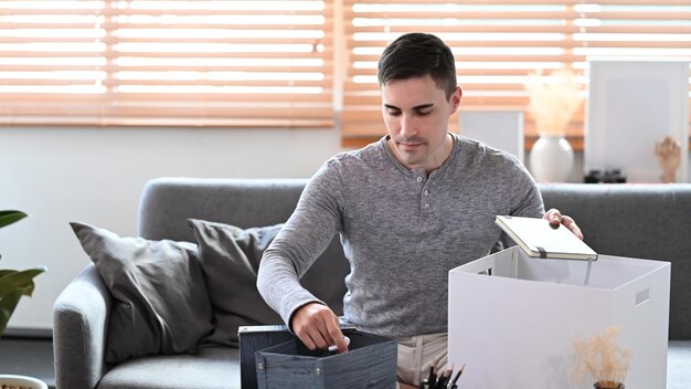 Young man preparing personal stuff for moving into new house