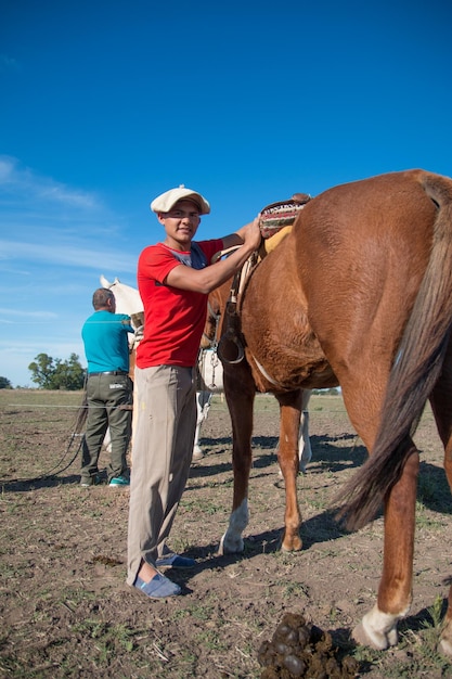 Young man preparing to ride horse