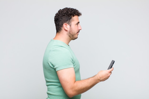 Young man on profile view looking to copy space ahead, thinking, imagining or daydreaming