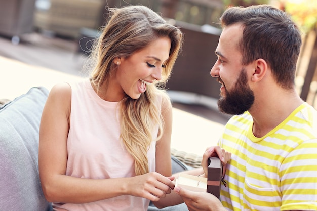 Photo young man proposing to beautiful woman outdoors