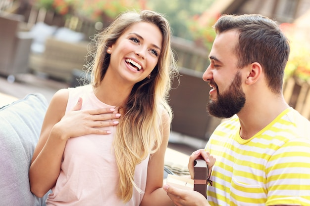 Giovane che propone alla bella donna all'aperto