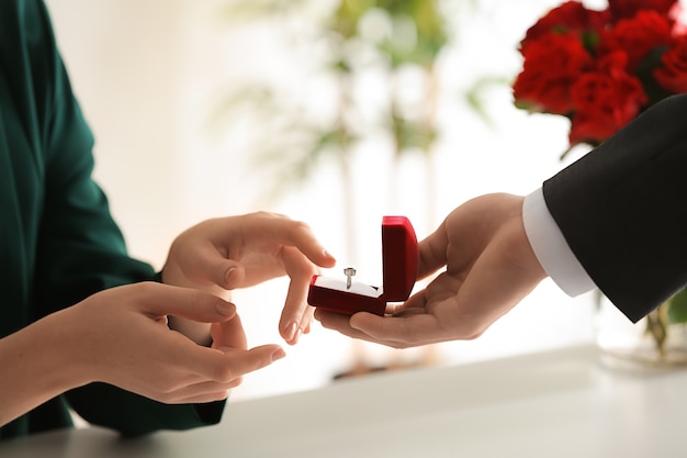 Young man proposing to his beloved at romantic date