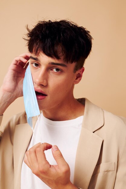 A young man protective mask in hand in hand modern style light background unaltered