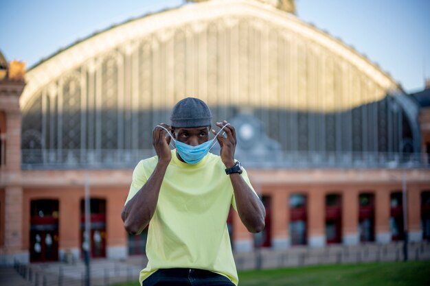 Young man putting on a surgical mask