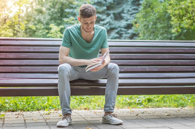 公園で本を読んでいる若い男