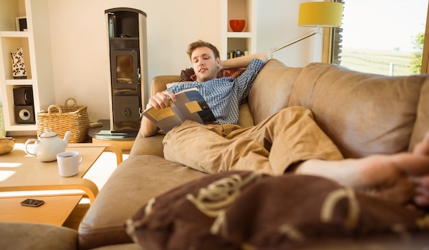 Photo young man reading on his couch