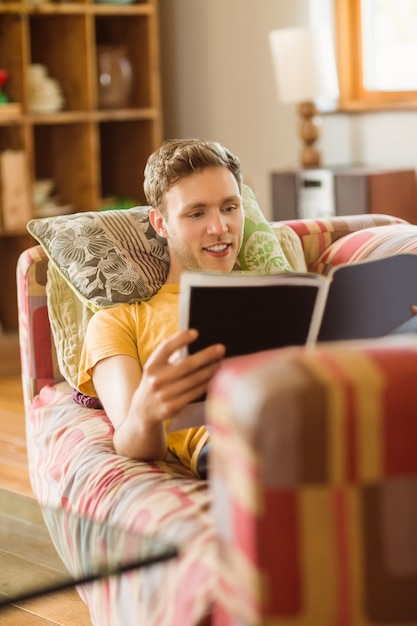 Young man reading magazine on his couch