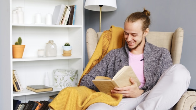 Un giovane legge un libro in un interno accogliente.