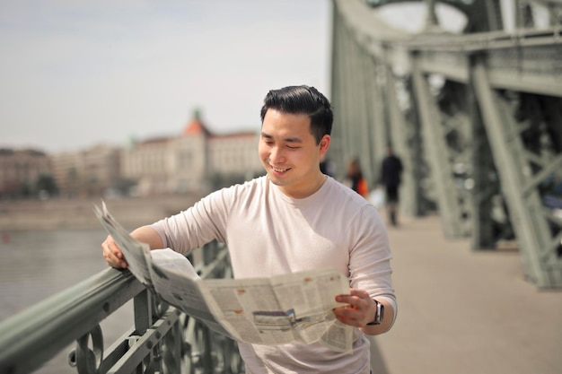 若い男が街で新聞を読む