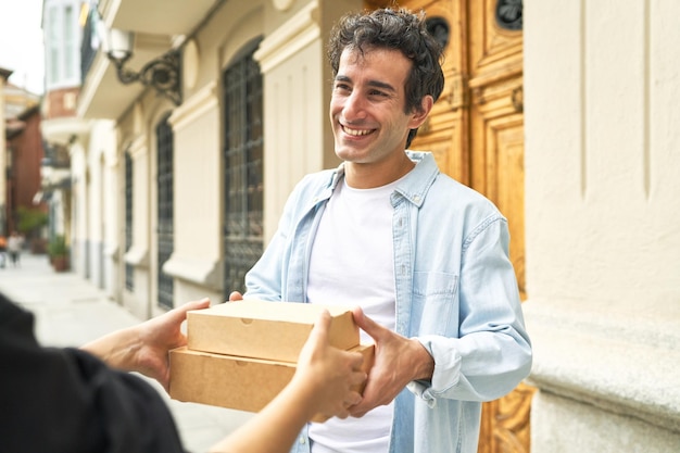 Young man receives a warm welcome at his doorstep with delicious food delivery