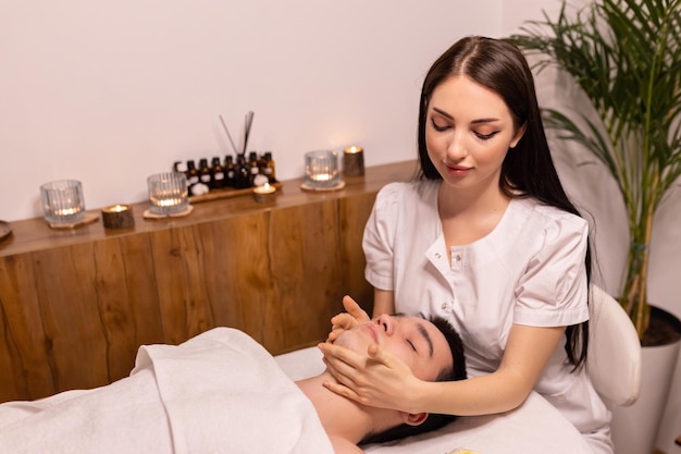 Young man receiving massage at spa salon