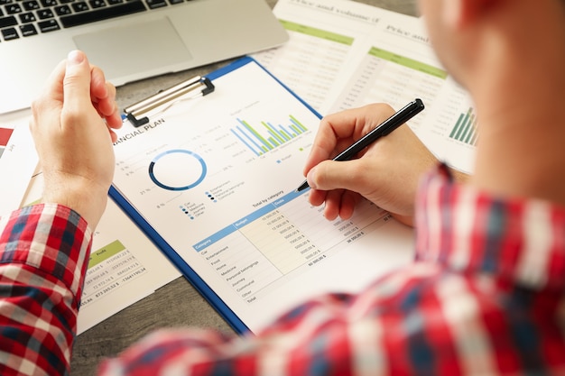 Young man in red shirt is engaged in financial planning