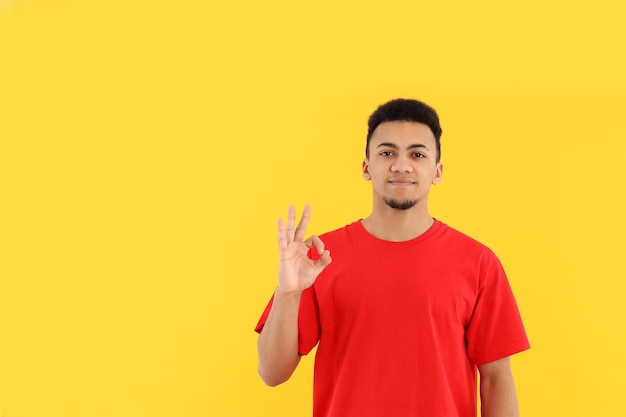 Young man in red t-shirt on yellow background
