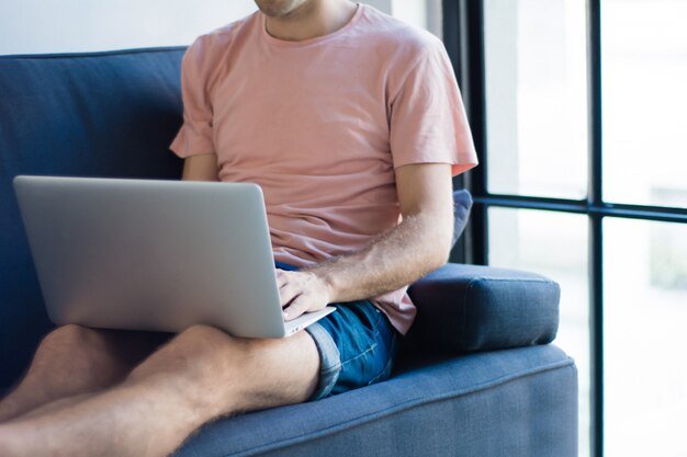 Young man relaxing on the sofa with a laptop 