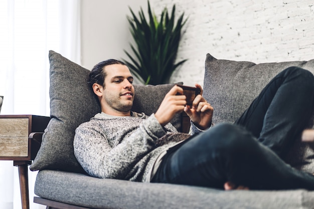 Young man relaxing and using smartphone.man checking social apps and working.Communication and technology concept