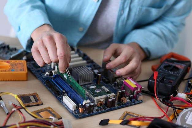 サービスセンターでコンピューターハードウェアを修理する若い男