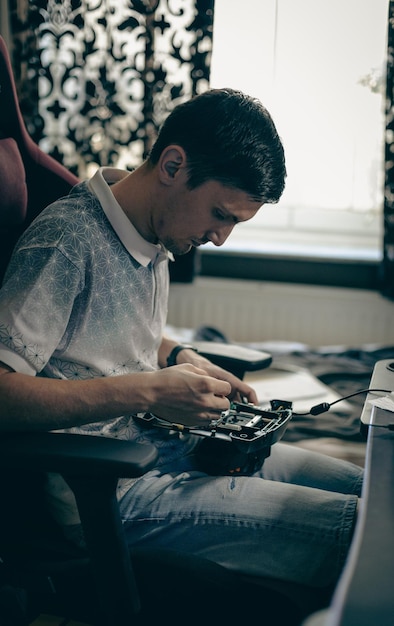 A young man repairs the engine steering wheel on a joystick