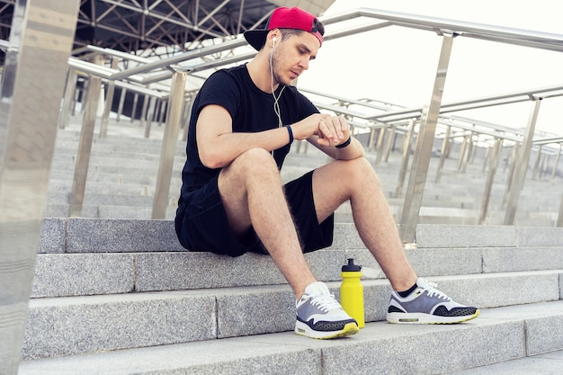 Young man resting on the stairs after running.