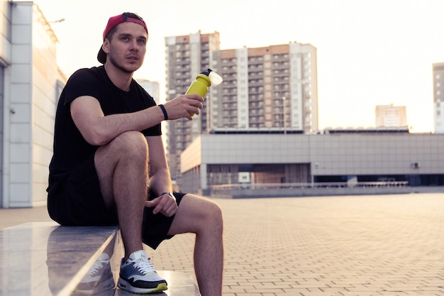 Young man resting on the stairs after running.